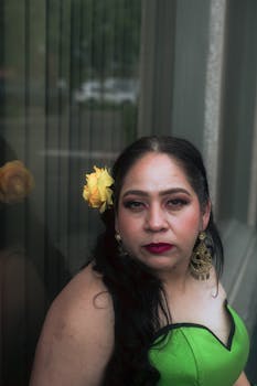 Portrait of a woman in a green dress with yellow flower accessory, reflecting elegance and style.