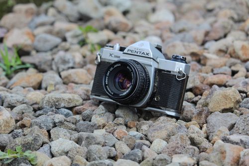 Free Classic vintage Pentax camera resting on a rocky surface outdoors in Indonesia. Stock Photo
