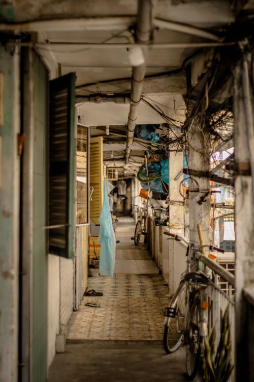 Free A narrow, rustic urban alleyway featuring a bicycle and laundry hanging, showcasing everyday life. Stock Photo