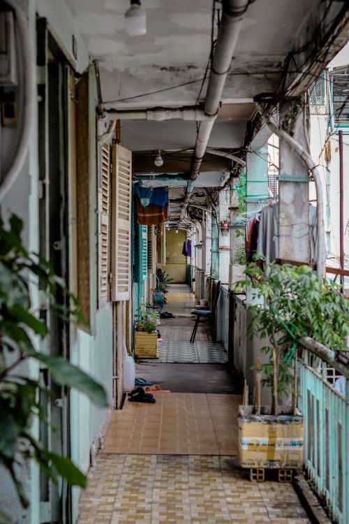 Free Long narrow balcony with plants and hanging laundry, depicting urban life. Stock Photo