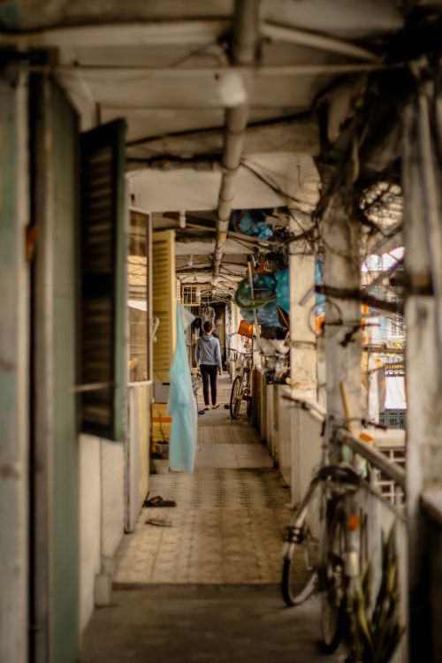Free A narrow balcony with a bicycle and a person walking away, depicting urban life. Stock Photo