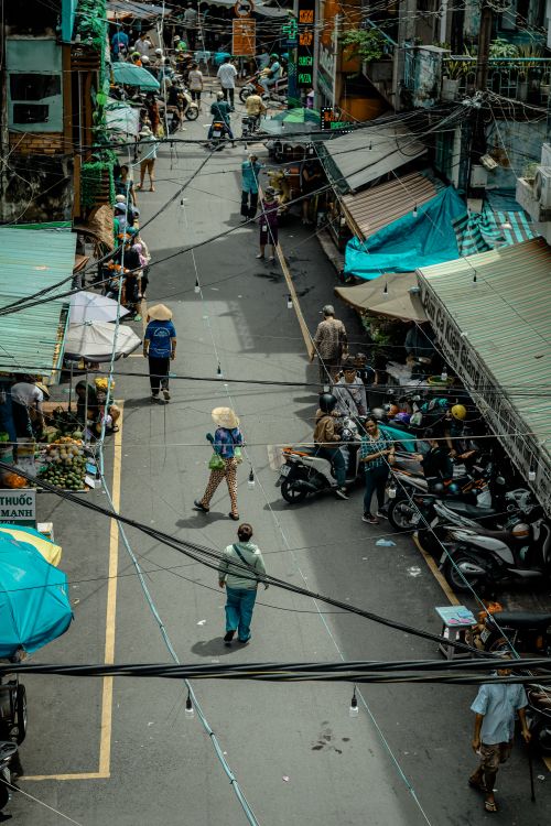 Free Dynamic street view capturing vibrant life at a Vietnamese market filled with people and shops. Stock Photo