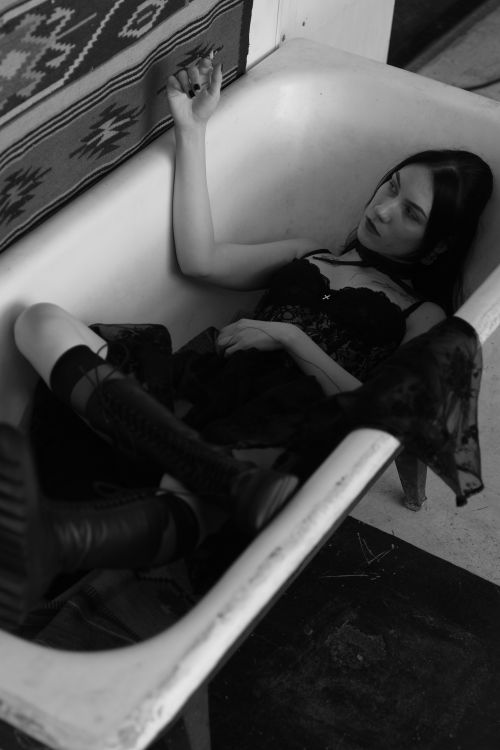 Free Artistic black and white portrait of a woman lying in a bathtub, conveying introspection. Stock Photo