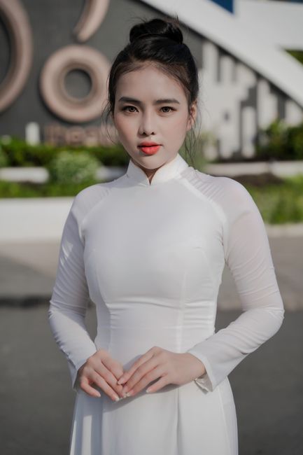Elegant woman wearing traditional Vietnamese Ao Dai outdoors. Bright and poised.
