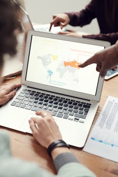 同事们正在用一台笔记本电脑讨论全球业务演示