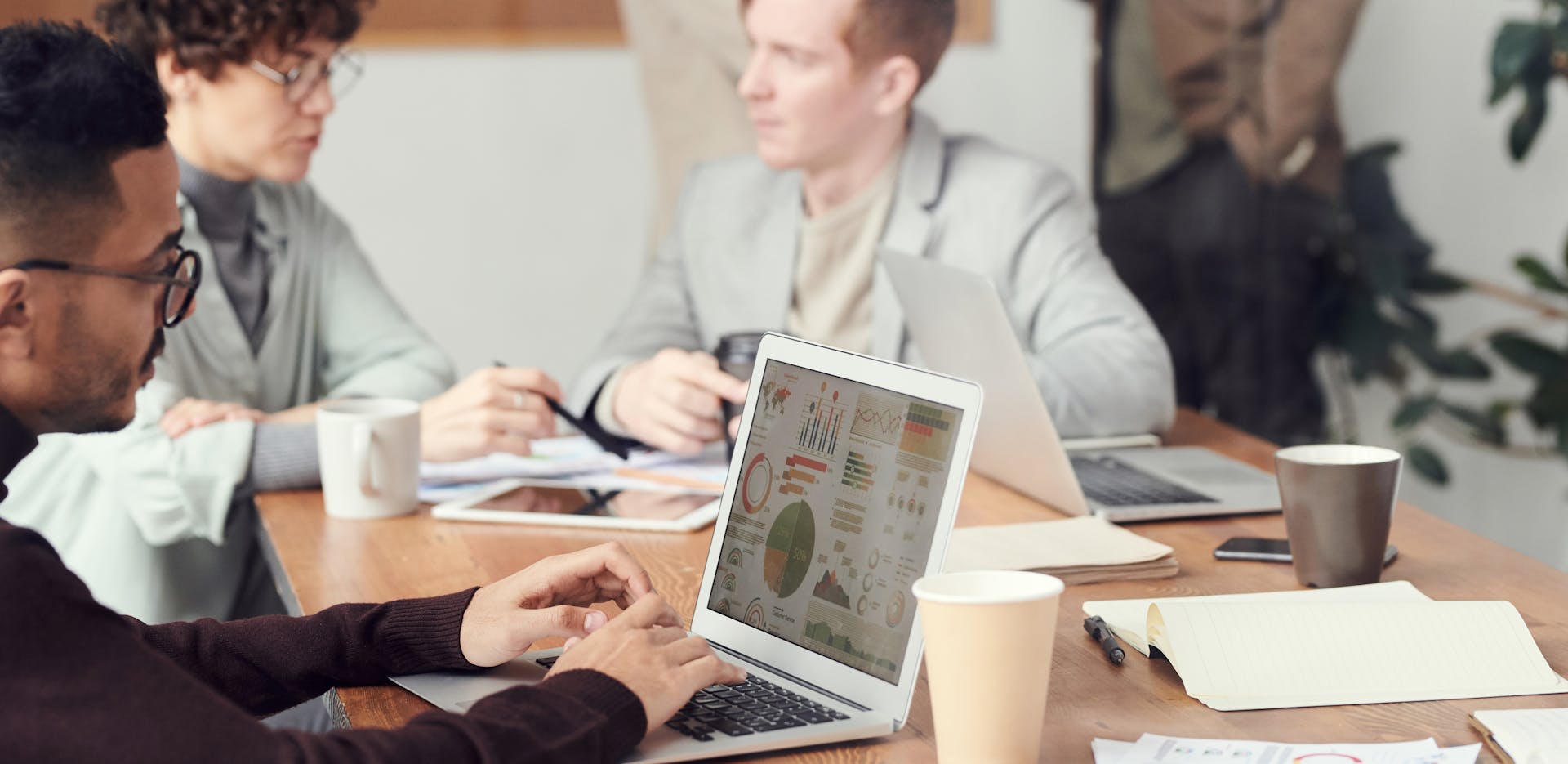 Professionals collaborating in an office setting, focused on digital data analysis during a meeting.