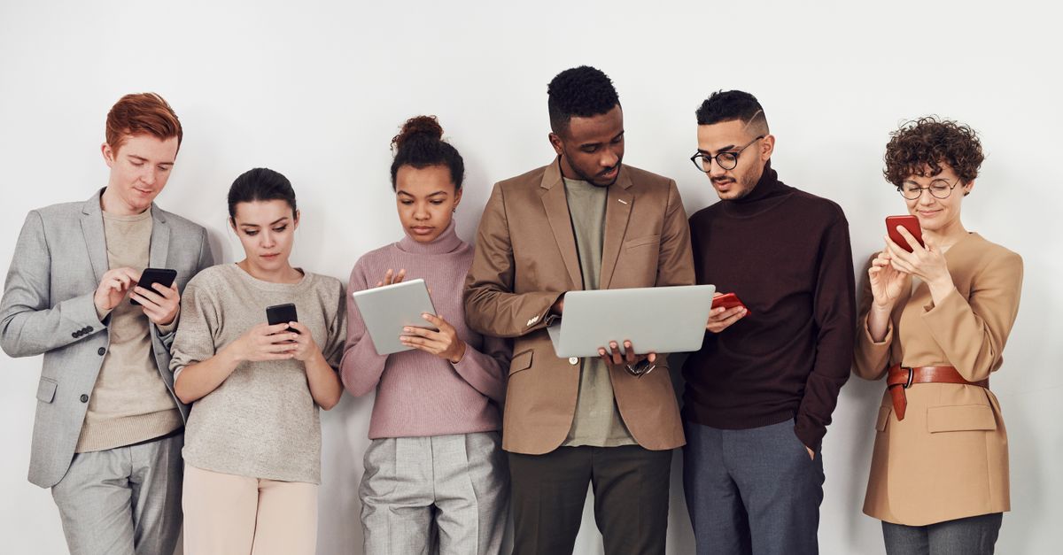A diverse group of professionals learning on smartphones and tablets in a modern office lounge