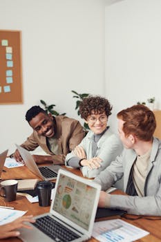 在配备笔记本电脑和文件的现代化办公空间里，多元化的团队进行了一场集思广益会议