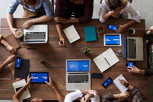 Free Top View Photo Of People Near Wooden Table Stock Photo