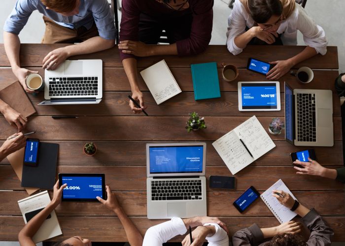 Team collaborating around laptops