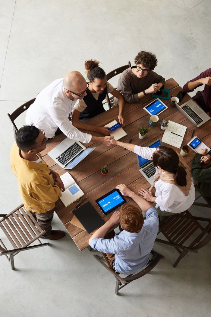Overhead view of a team collaborating with laptops