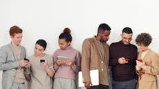 五名穿着休闲装的成年人在室内使用手机和平板电脑，突显科技与时尚感