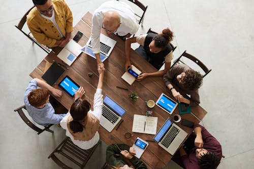 People shaking hands across a meeting table