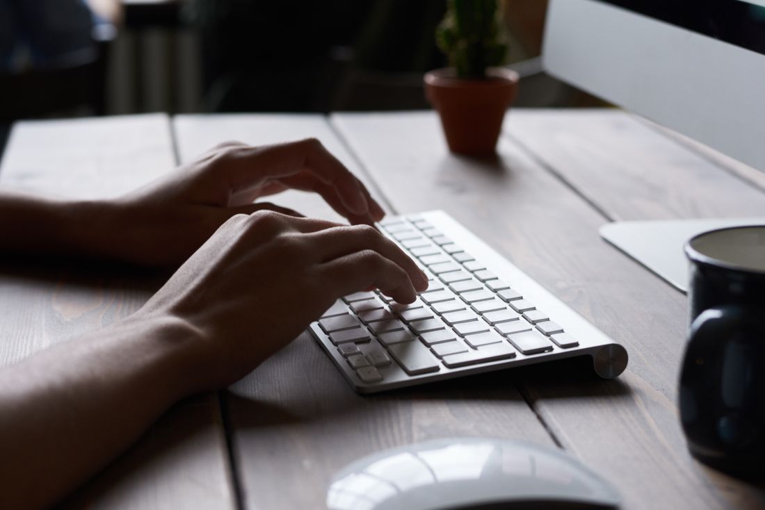 hands typing on keyboard dark