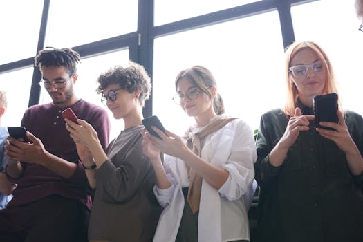 明亮的室内环境中，四名成年人微笑着与智能手机互动