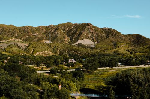 Free Stunning mountain range with lush greenery and tranquil scenery under a clear blue sky. Stock Photo
