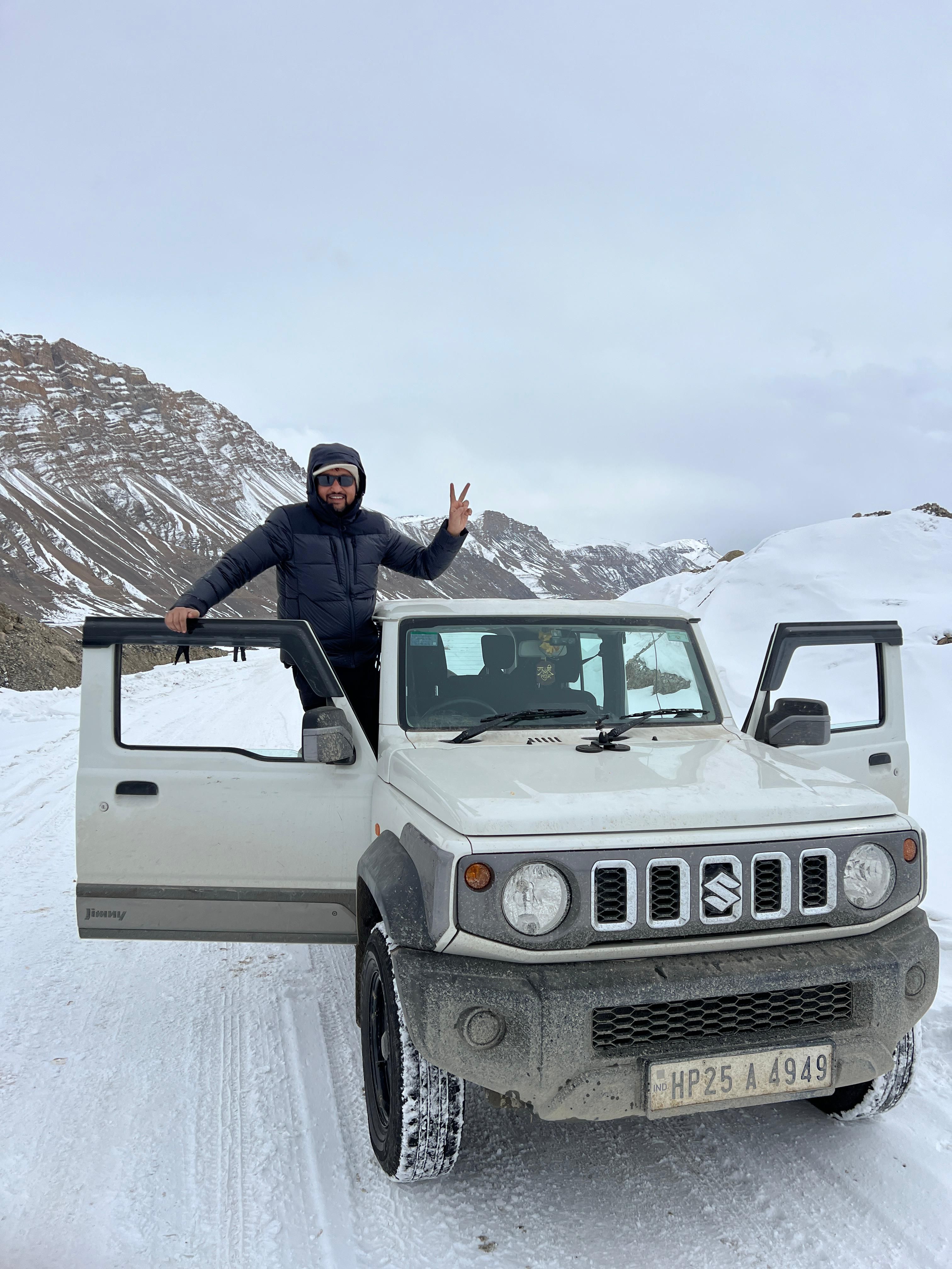 A winter road trip adventure in snowy Himachal Pradesh, India, showcasing a rugged vehicle and mountainous landscape.