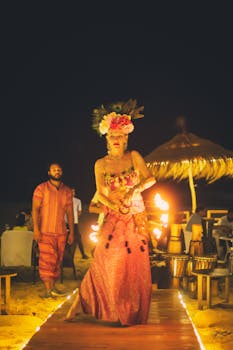 Colorful fire dancer performing at a lively beach festival in India, showcasing traditional costumes and vibrant culture.
