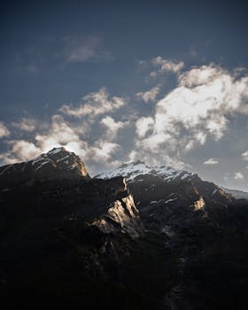 Majestic Himalayan mountains under a dramatic twilight sky, showcasing snow-capped peaks and vibrant clouds.