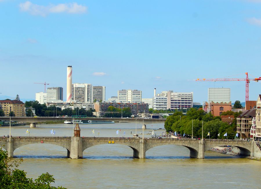Beautiful view of Basel's historic bridge over the Rhine River with city skyline in the background.