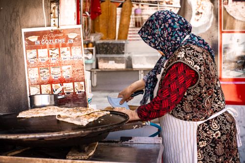 Free A woman prepares authentic Gözleme at a street food stall in Istanbul, showcasing Turkish culinary traditions. Stock Photo