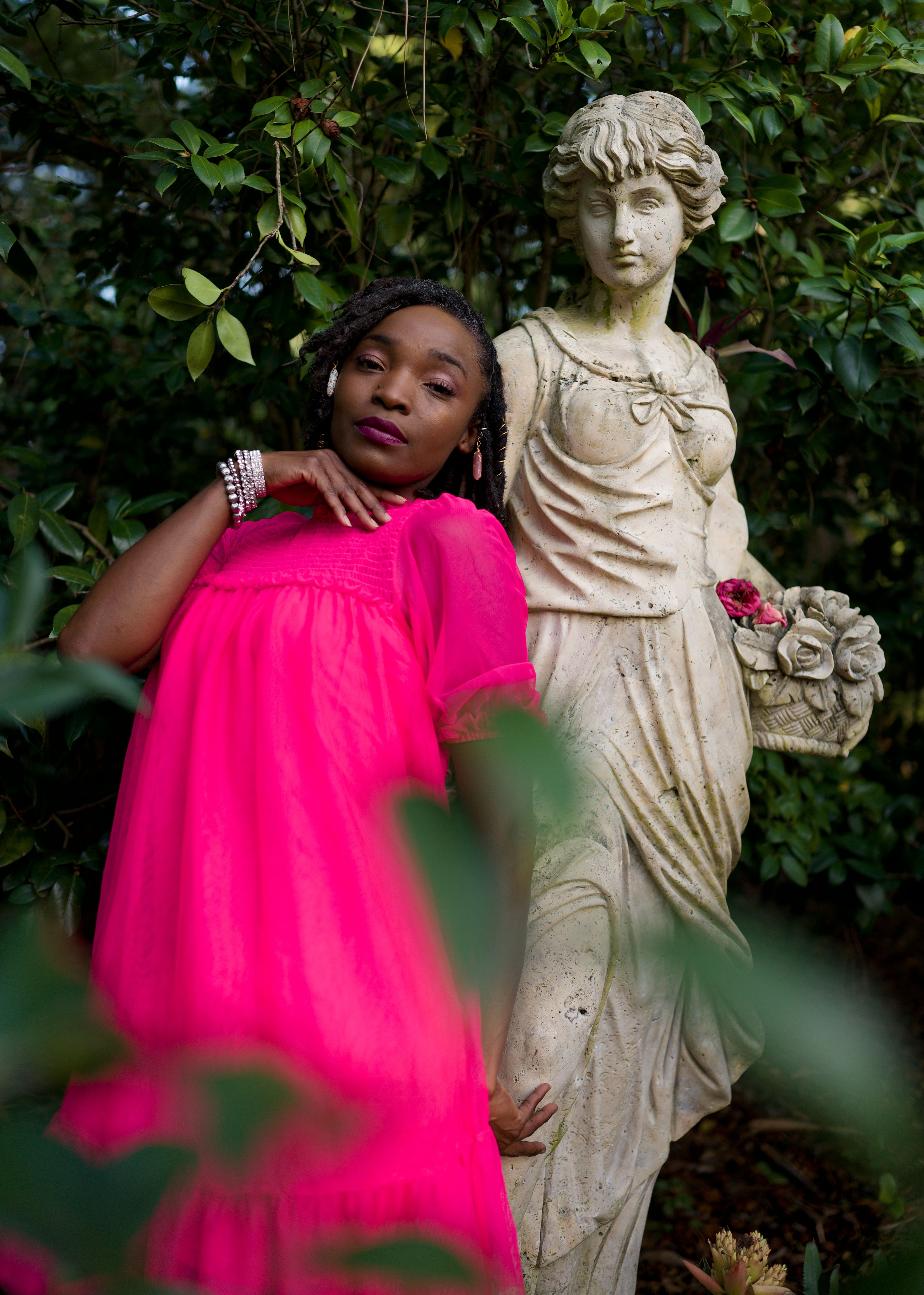 Elegant Woman Posing with Garden Statue · Free Stock Photo