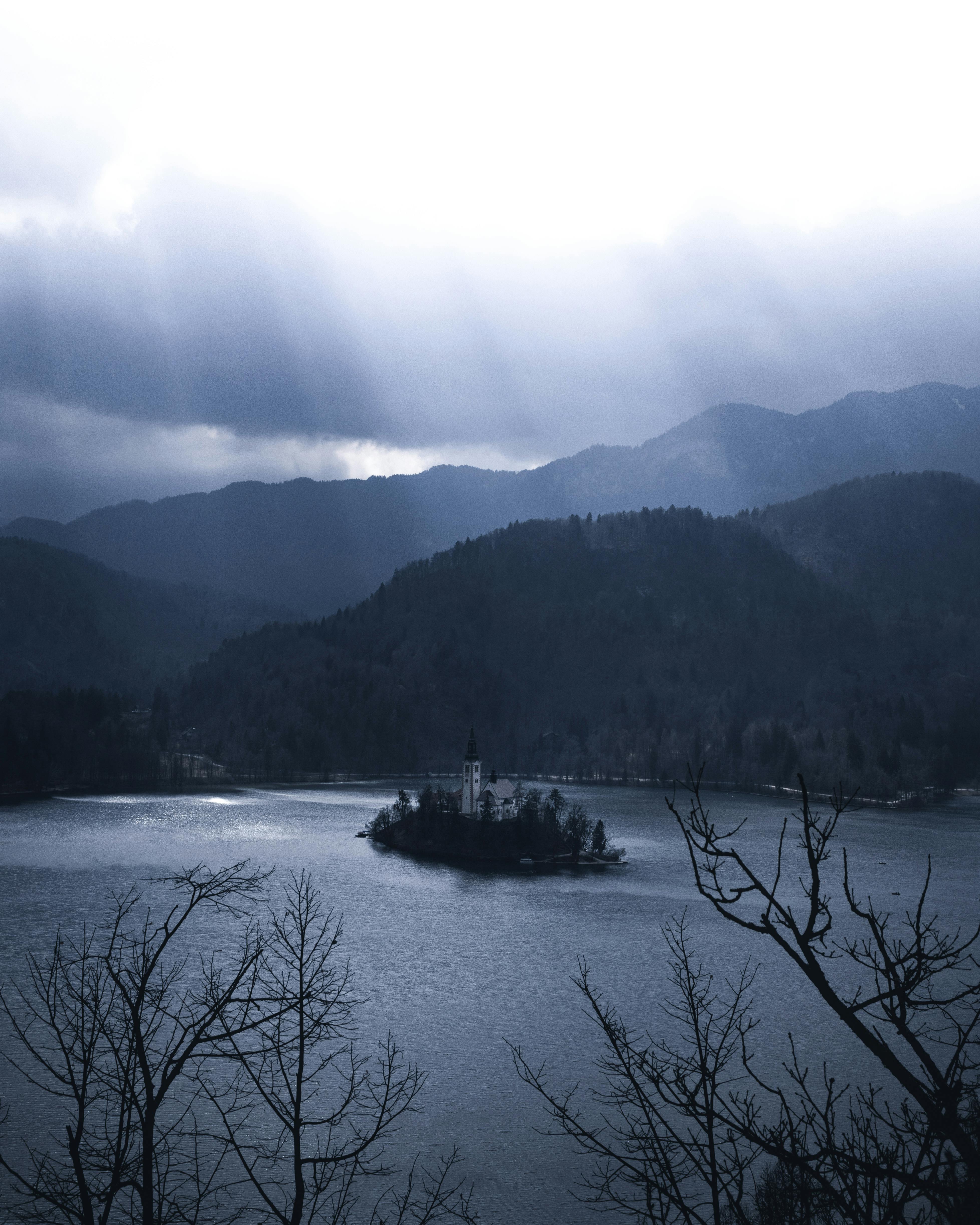 布莱德岛冬季的景色宁静，教堂和山脉在多云的天空下静静矗立