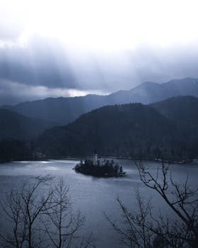 布莱德岛冬季的景色宁静，教堂和山脉在多云的天空下静静矗立