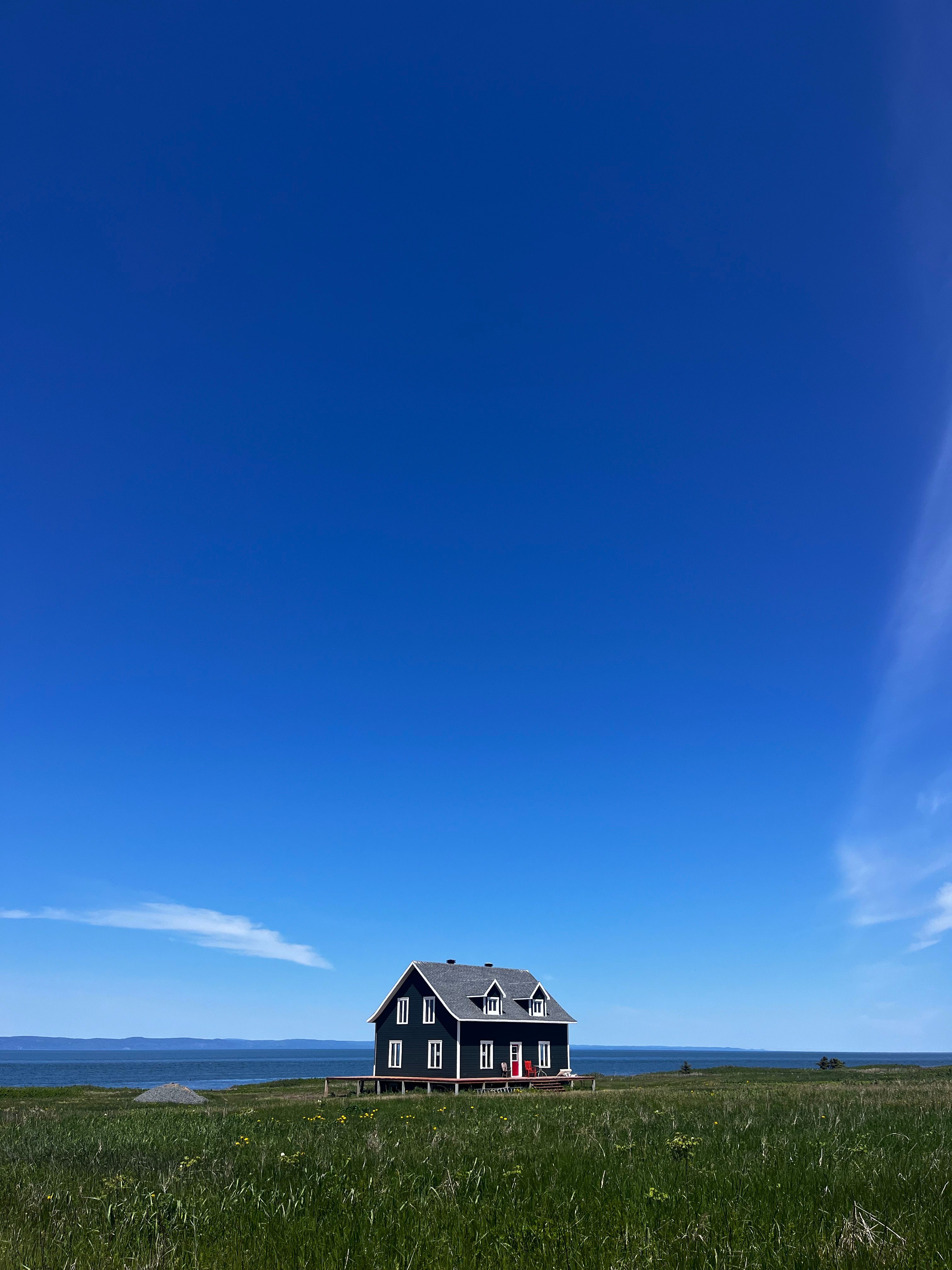 Charming Coastal Cottage Under Clear Blue Sky · Free Stock Photo