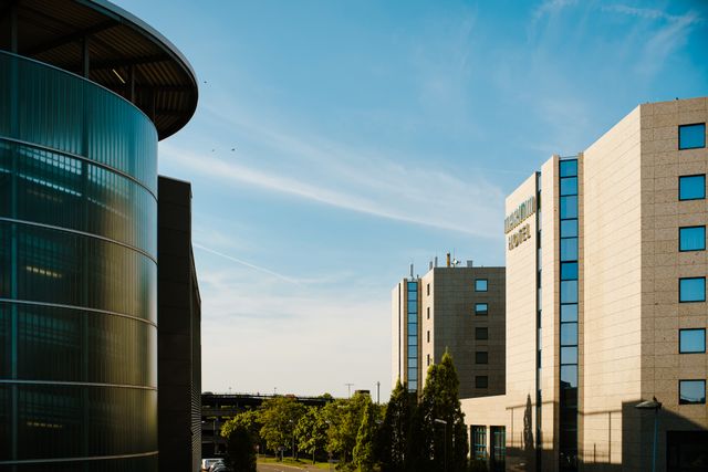 Contemporary hotel architecture with blue sky backdrop in city environment. Related image for The New Revenue Questions Hotel Owners Should Ask.