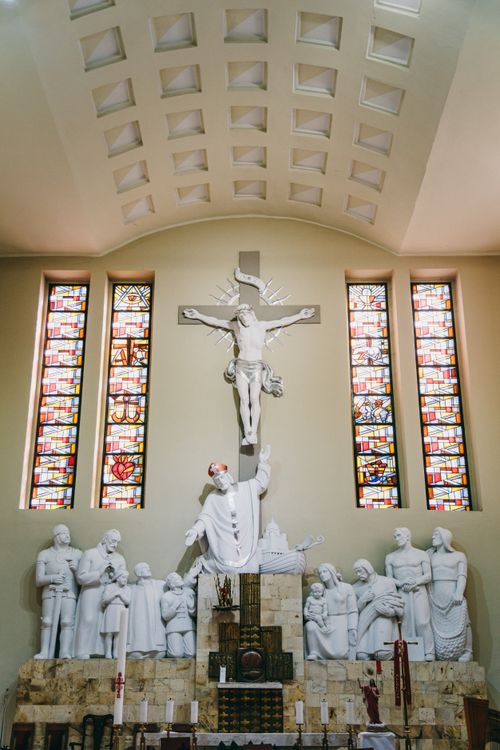 Free A serene view of a Catholic church's altar with religious statues and stained glass windows in Poland. Stock Photo