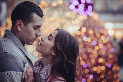 Photo of Couple Kissing In Front Of Christmas Tree · Free Stock Photo