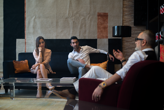 Three adults engaged in a thoughtful therapy session in a stylish Genoa interior.