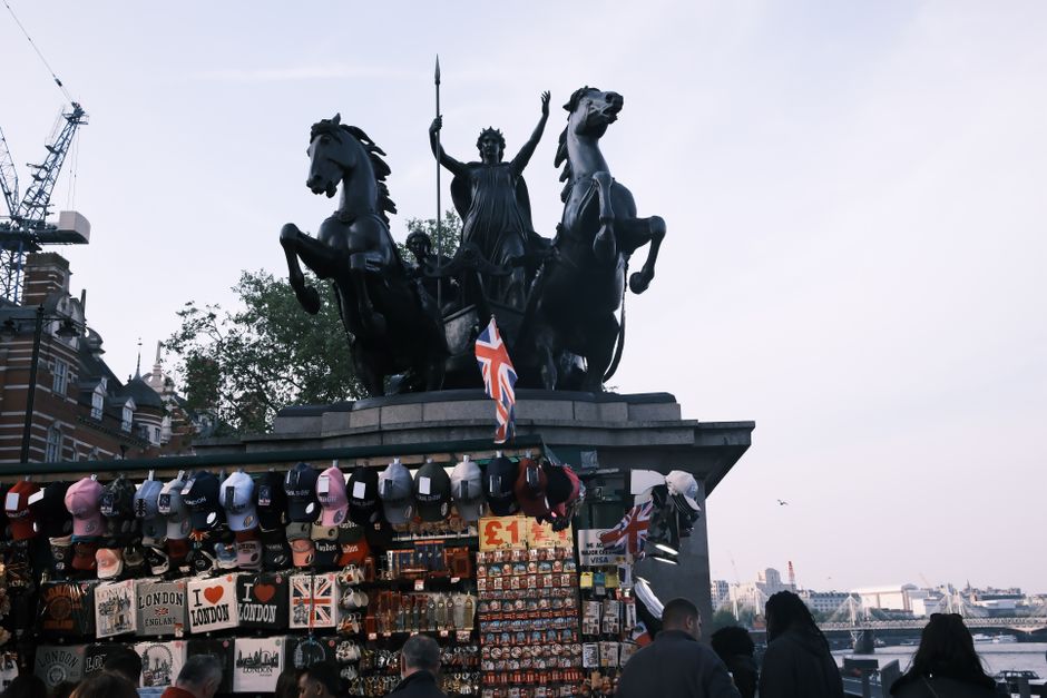 Iconic Boudica statue with London souvenirs under a cloudy sky near River Thames.