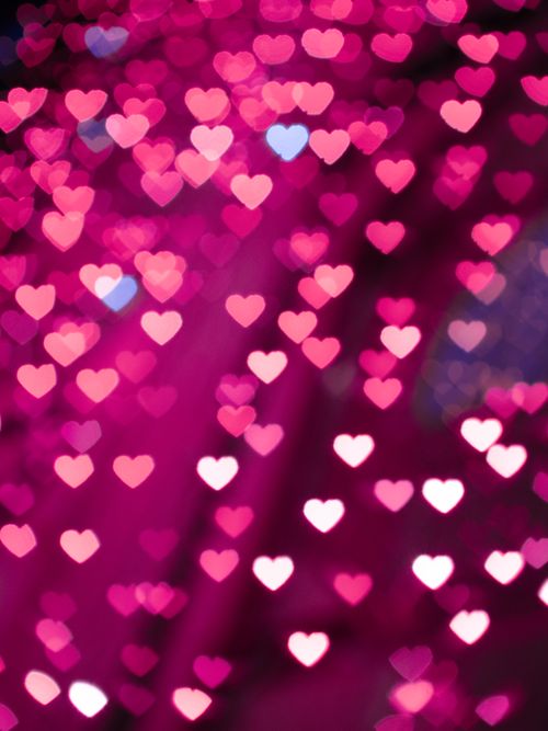 Free Blurred heart bokeh lights in pink tones create a romantic and dreamy background. Stock Photo