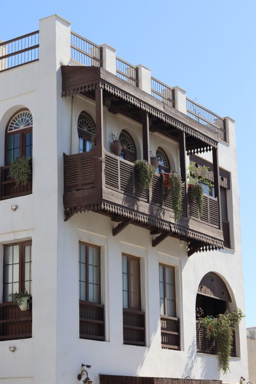 Free A vibrant Middle Eastern balcony with lush plants under a clear sky, showcasing traditional architecture. Stock Photo