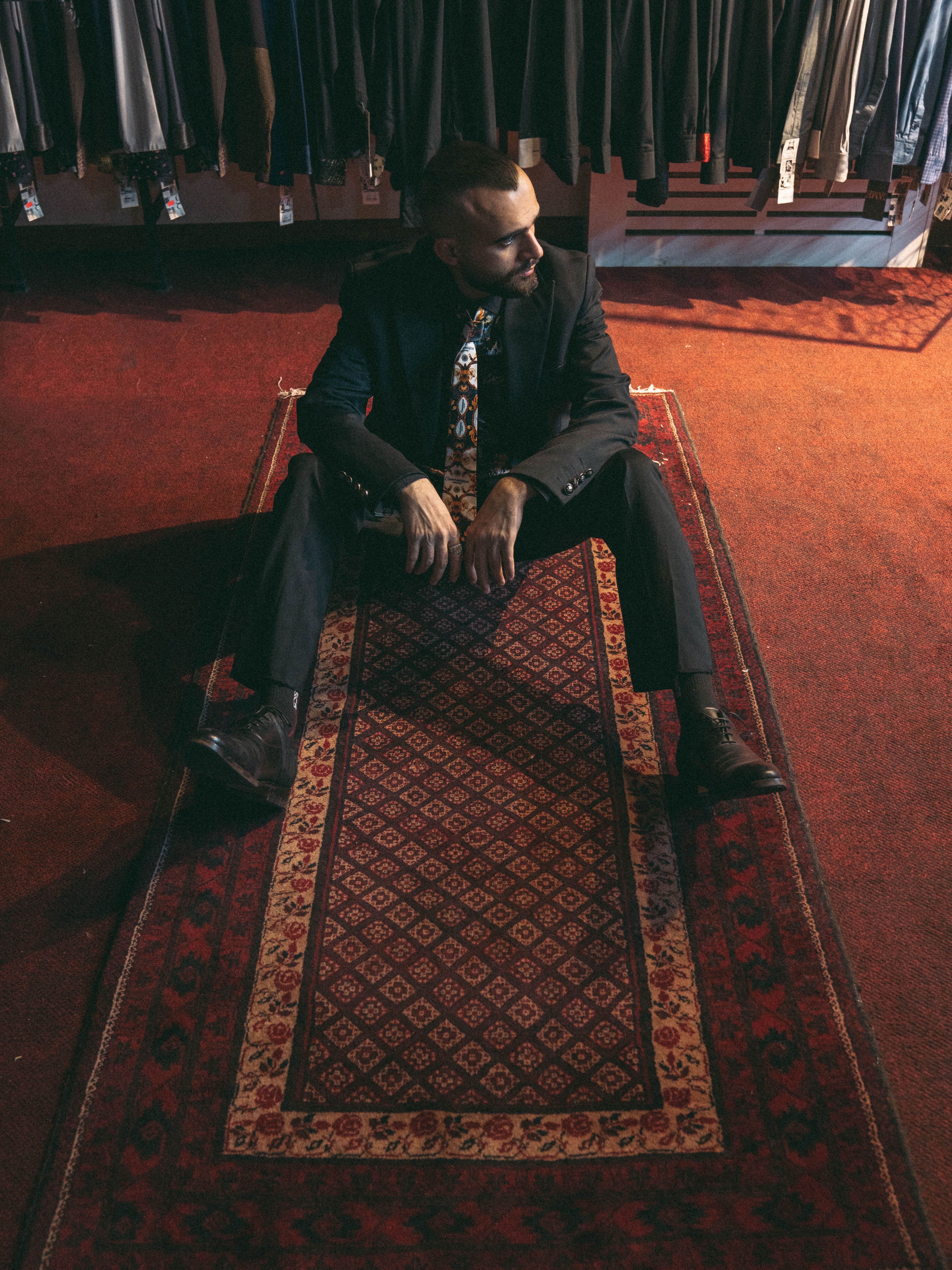Man in Suit Relaxing on Decorative Carpet · Free Stock Photo
