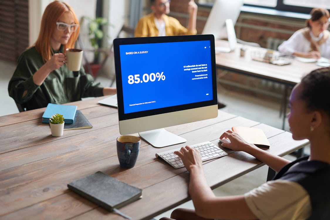 Woman in Front of Computer and Woman Holding a Mug