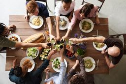 Shared plates and glasses crowding a long table