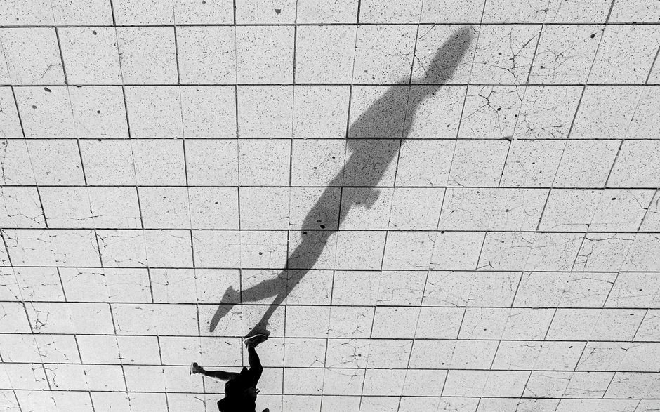 Black and white photo of a shadow on tiled pavement in Mar del Plata, Argentina.