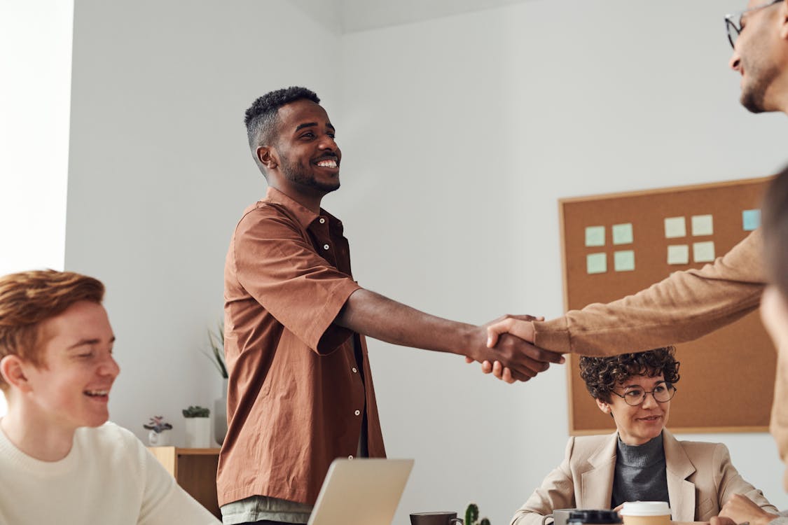 Man in Brown Sport Shirt Shaking Hands of Man