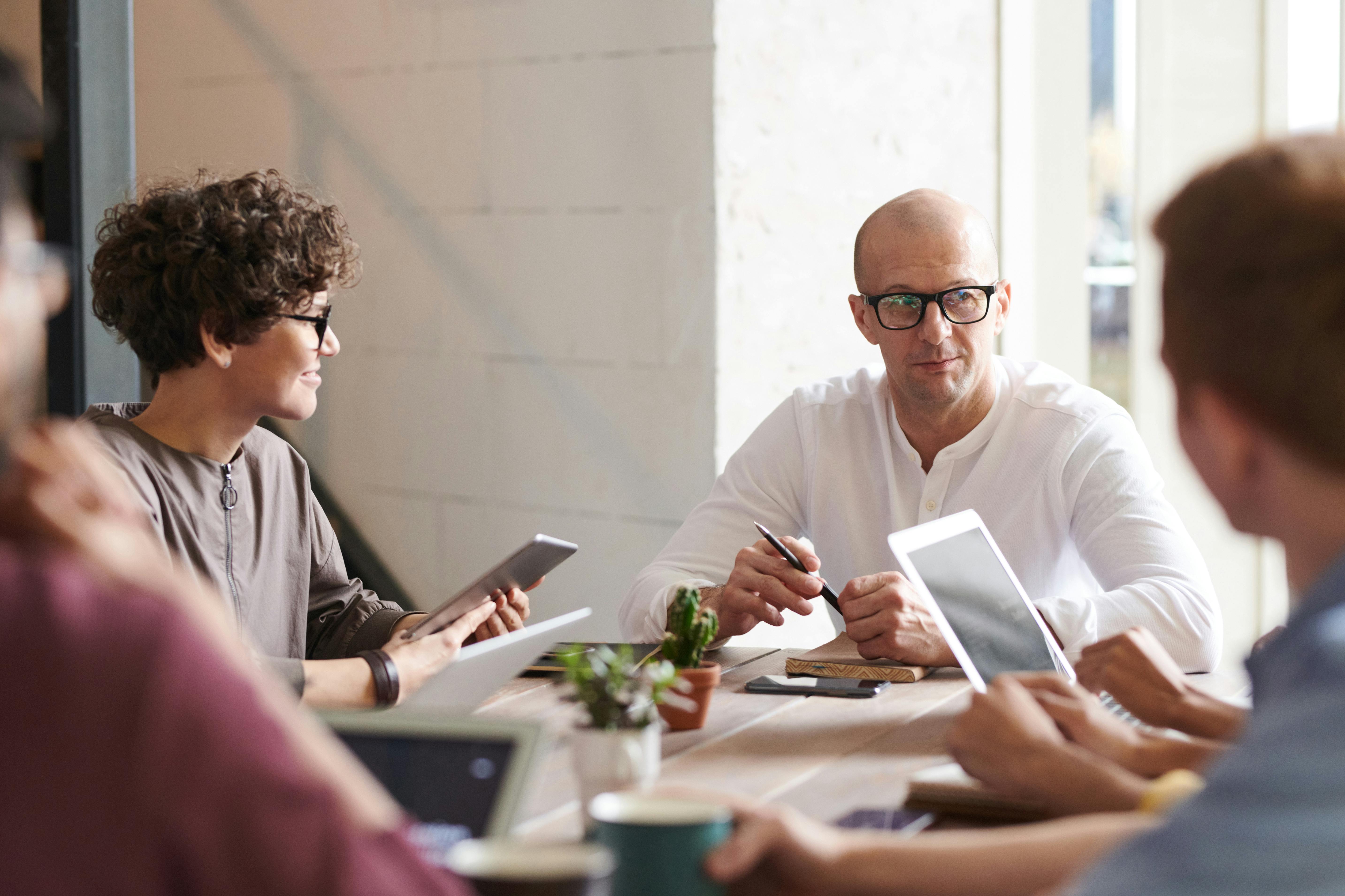 photo of man sitting in front of people