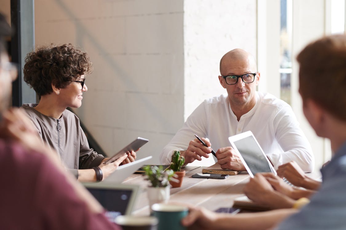 https://www.pexels.com/photo/photo-of-man-sitting-in-front-of-people-3184299/