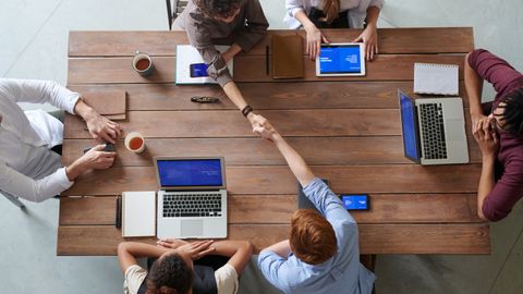 Equipo empresarial implementando inteligencia artificial paso a paso con colaboradores digitales