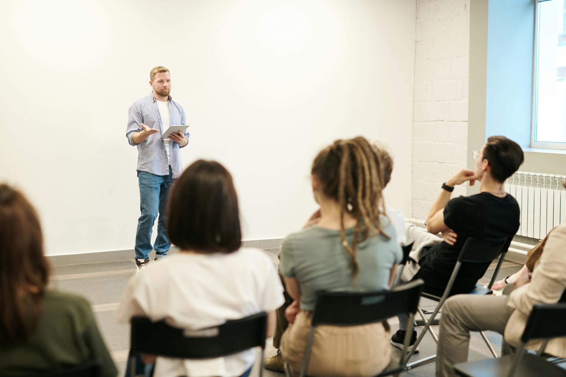 Man Wearing Gray Dress Shirt in Classroom