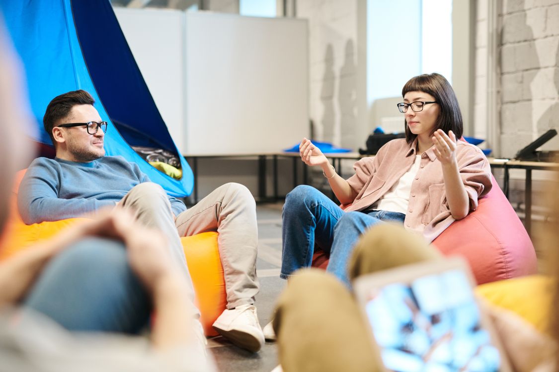 Two colleagues at a whiteboard, one erasing a complex diagram while the other watches thoughtfully