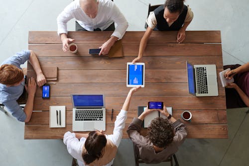 Grupo De Pessoas Sentadas Ao Redor Da Mesa Discutindo