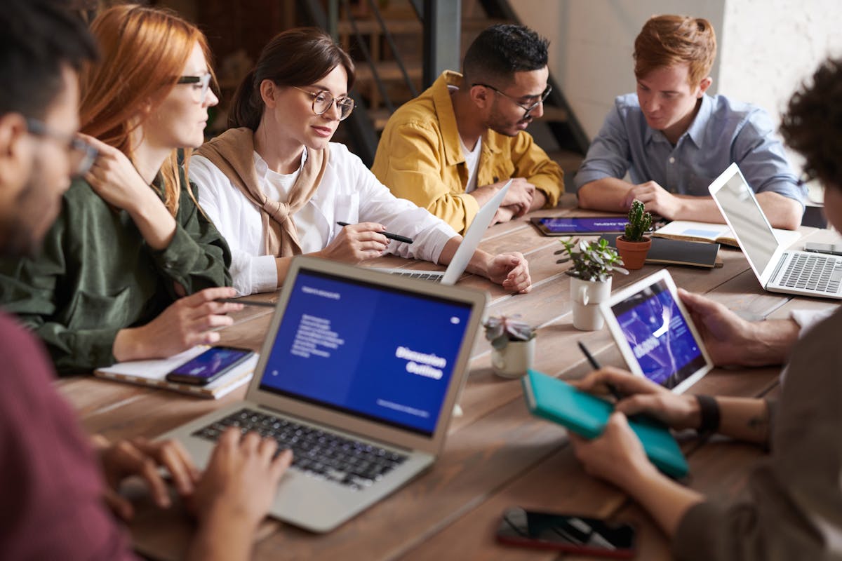 Diverse professional team collaborating around conference table discussing key employee retention strategies and business continuity planning