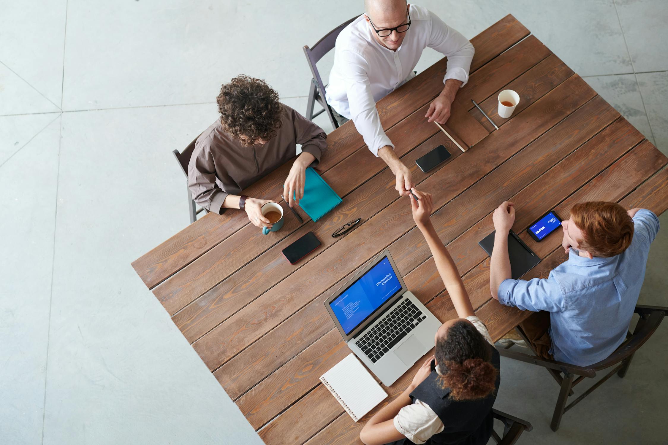 four people sitting at an office desk