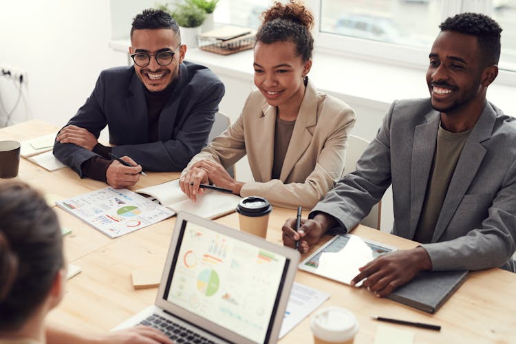 Photo Of Three People Smiling While Having A Meeting